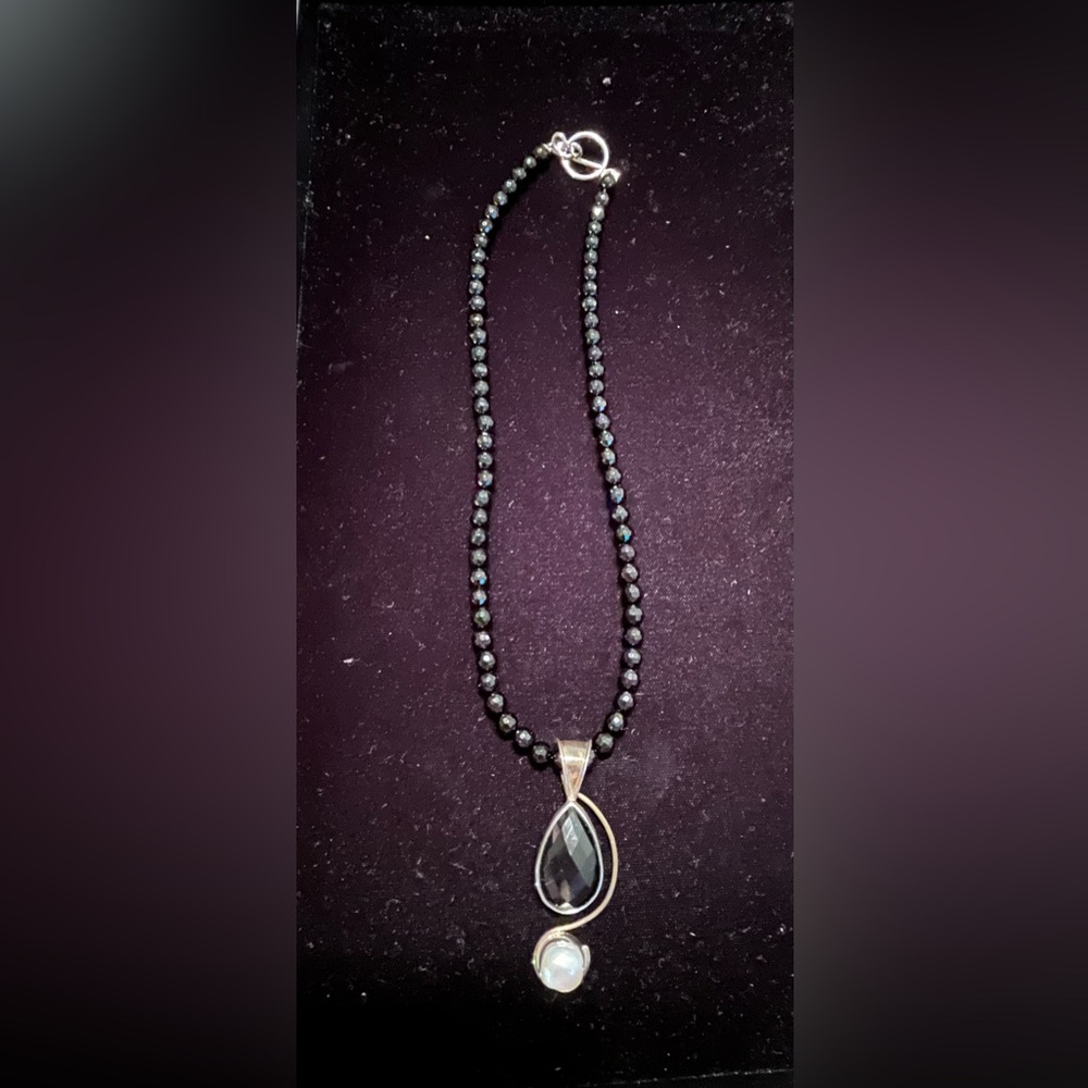 Black beaded costume necklace with synthetic pearl pendant.